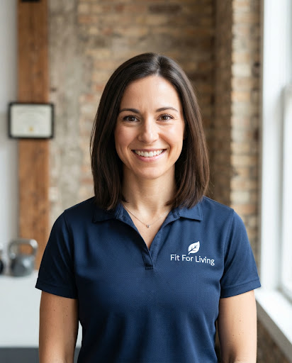Portrait headshot of athletic female trainer smiling warmly in navy collared coaching polo against clean architectural textured wall at 37 Mercer Street, natural soft daylight.